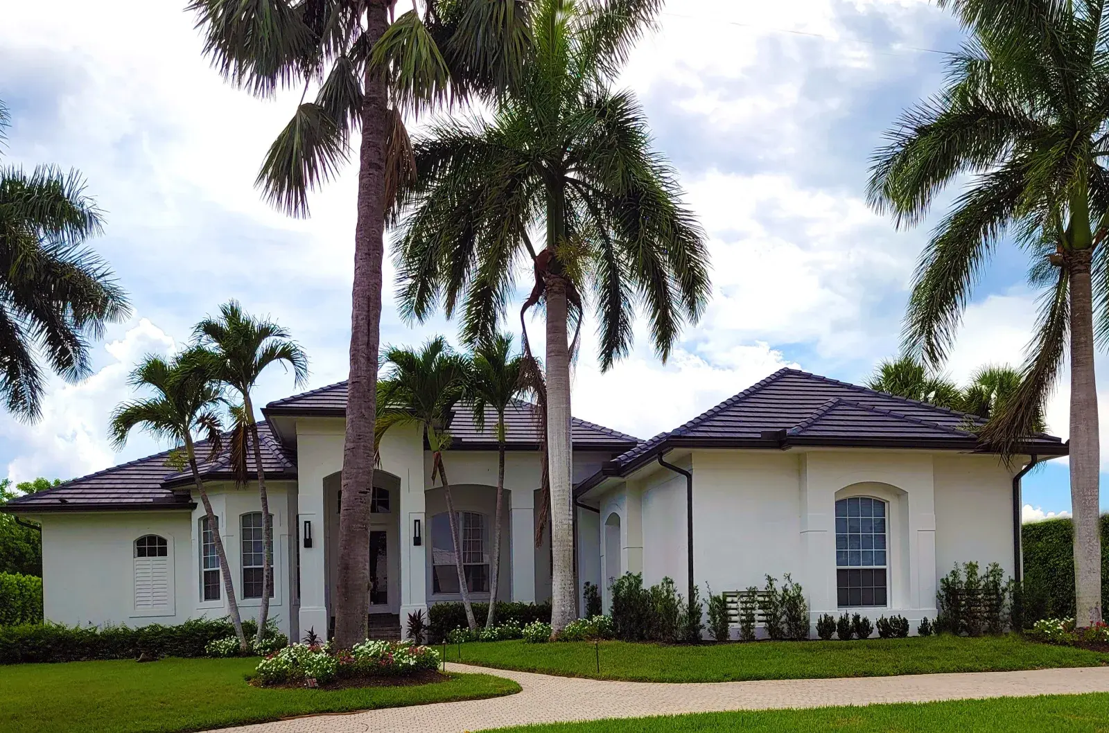 White residential Florida house in a tropical setting, representative of Titusville, FL's space-era ranch homes