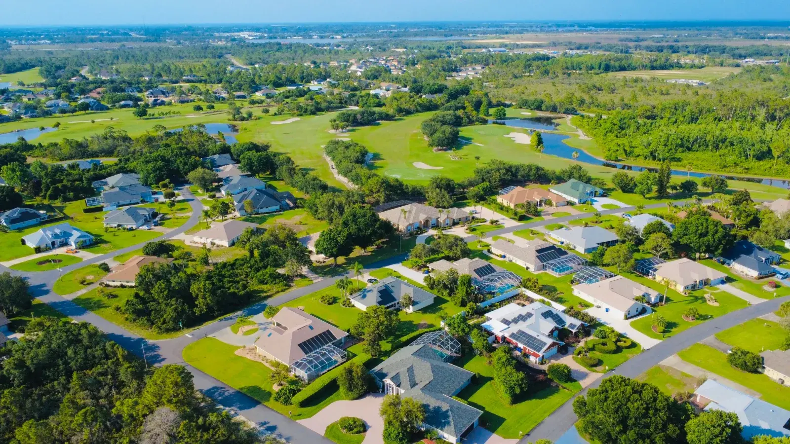 Drone view of a sunny suburban Florida neighborhood with solar panels, representative of Viera, FL's newer construction